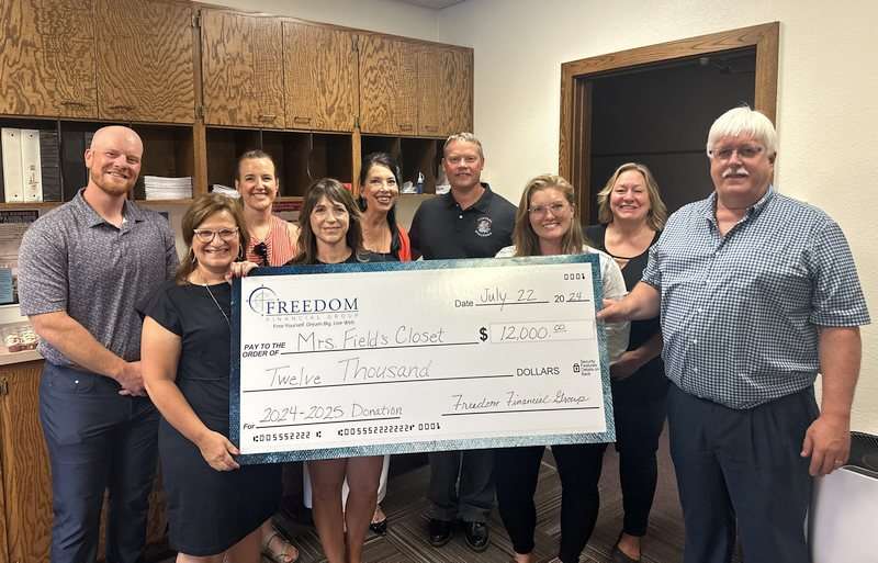 Mrs. Field's Closet receiving an oversized check donation from Freedom Financial